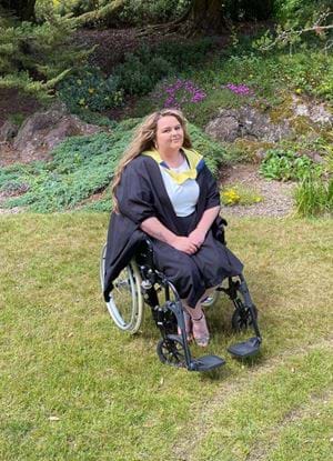 The image shows graduate Rochelle Savage posing in her gowns in a garden.