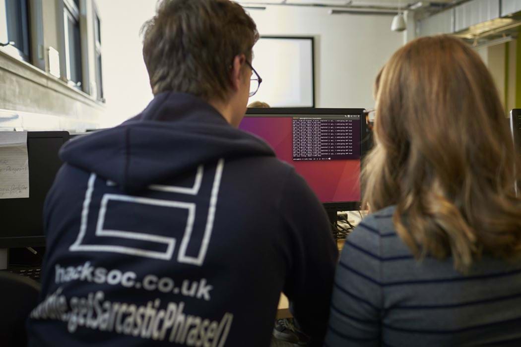 Picture of male and female from behind - male is wearing an Ethical Hacking Society hoody