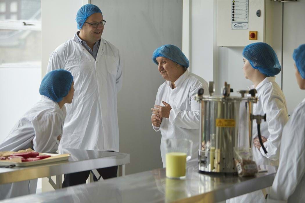 Group of people standing chatting in a food laboratory