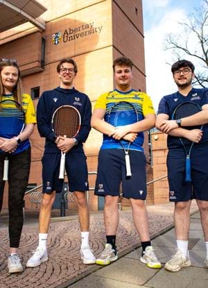 6 tennis club members holding racquets outside Abertay library