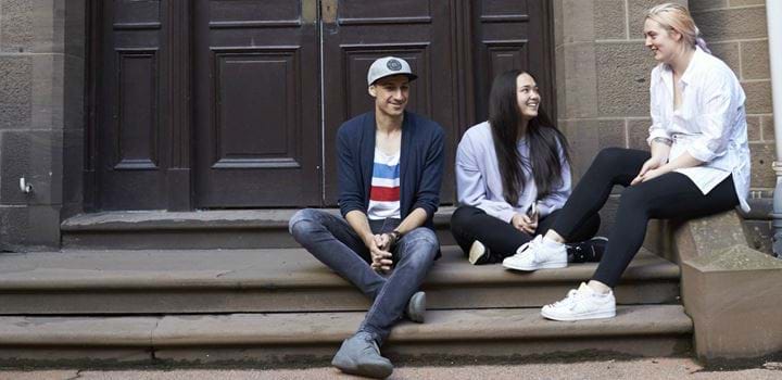 3 students sitting on steps
