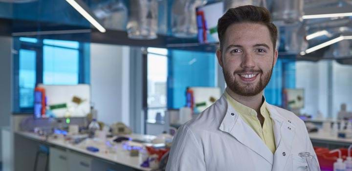 Smiling male standing in a science laboratory