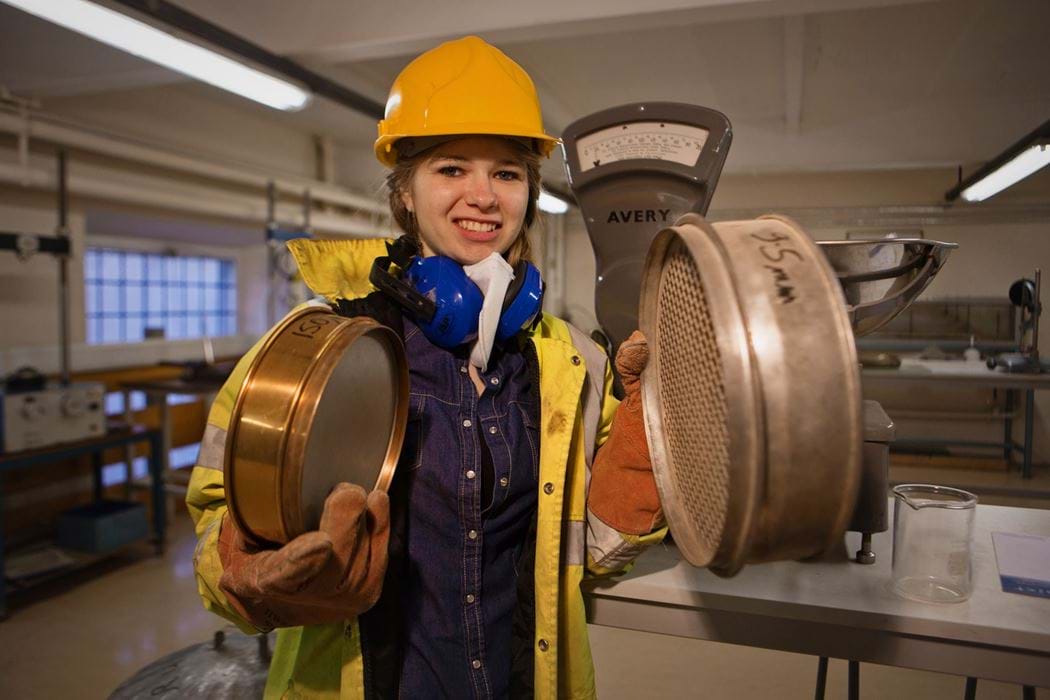 Female engineering student holding 2 circular objects