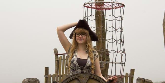 A photo of Jess Hider wearing a sea captain's hat. 