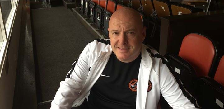 A photo of Joe Rice sitting in the stands at Tannadice