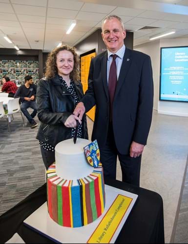 Nigel Seaton and Victoria Ryan cut Library reopening ceremony cake.