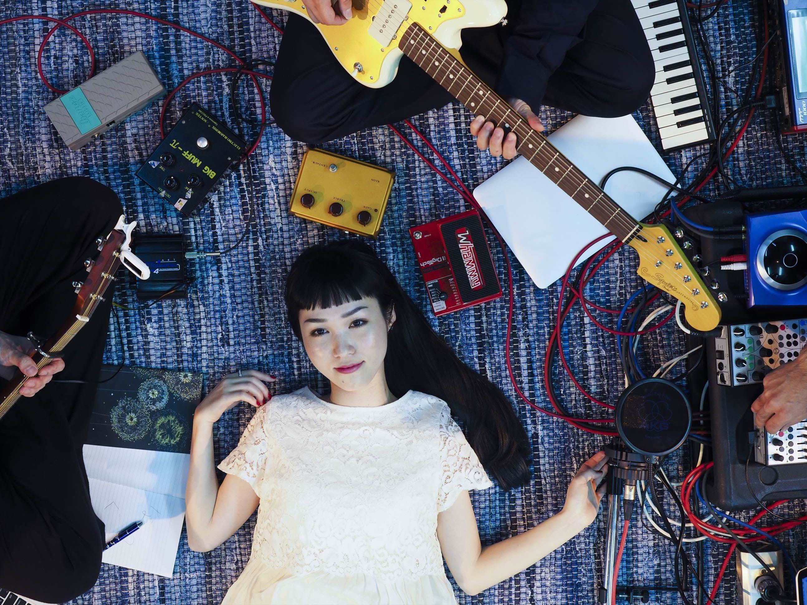 Music star Marico lying down with instruments placed around her