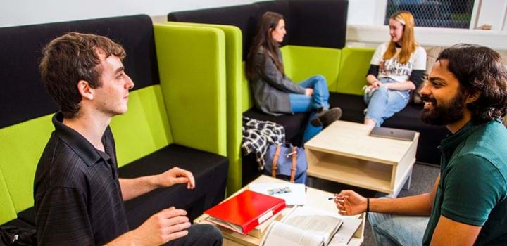 Students chatting in a social space on the Abertay campus.
