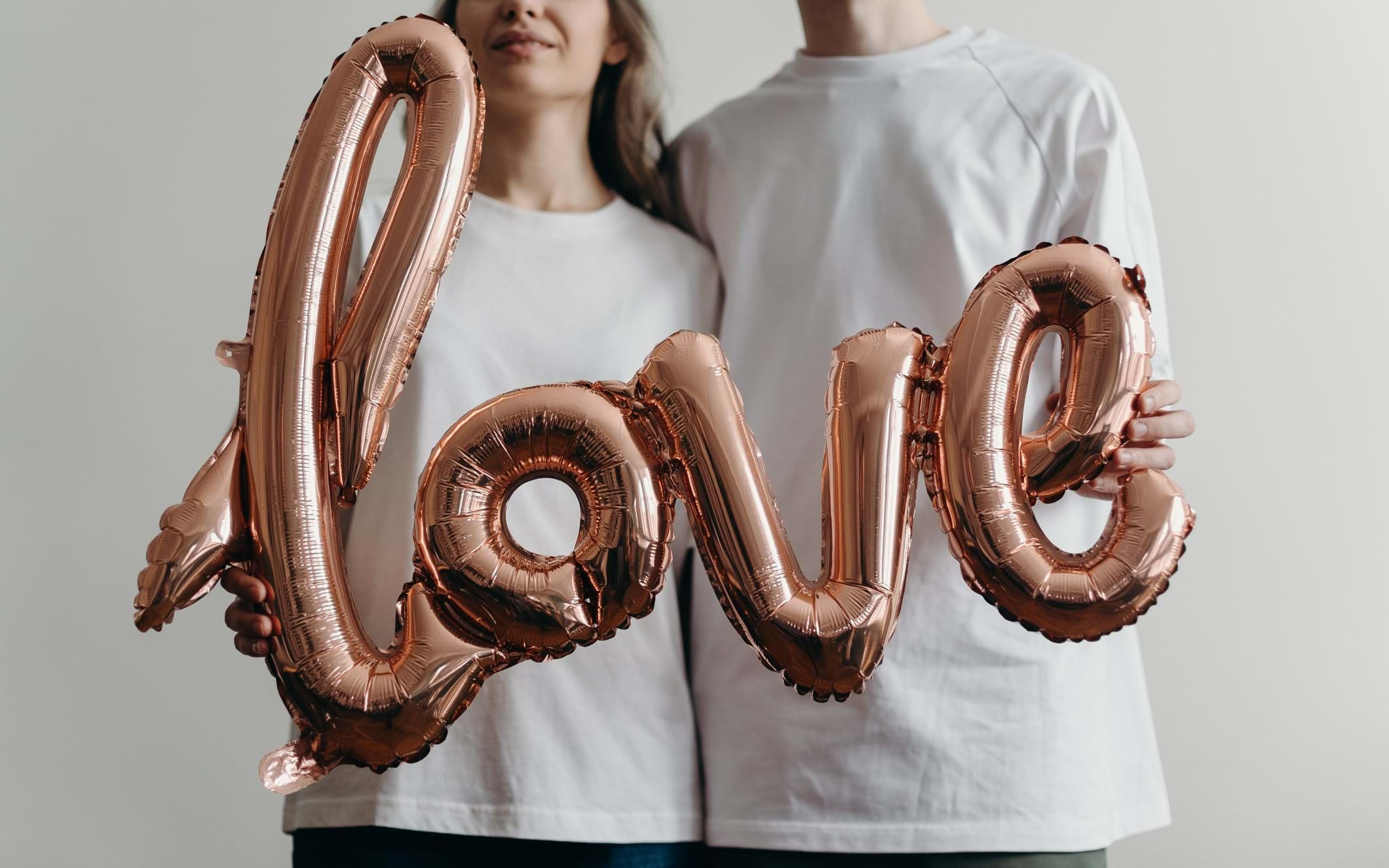 A couple holding a 'love' balloon
