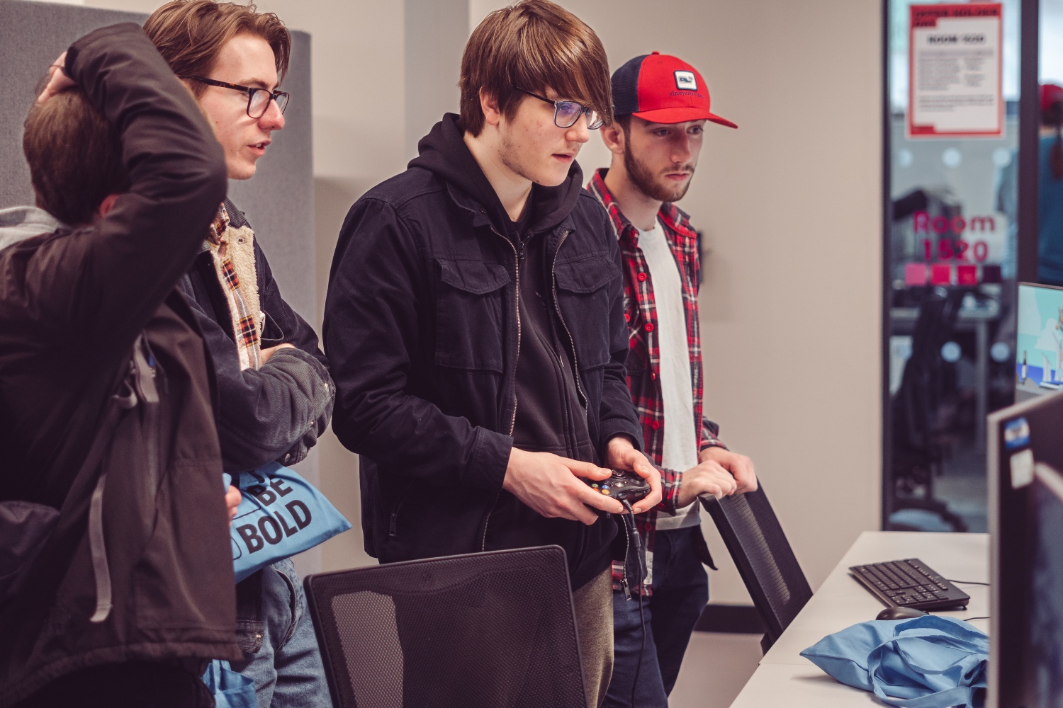 Four male applicants playing a video game at Offer Holder Day.