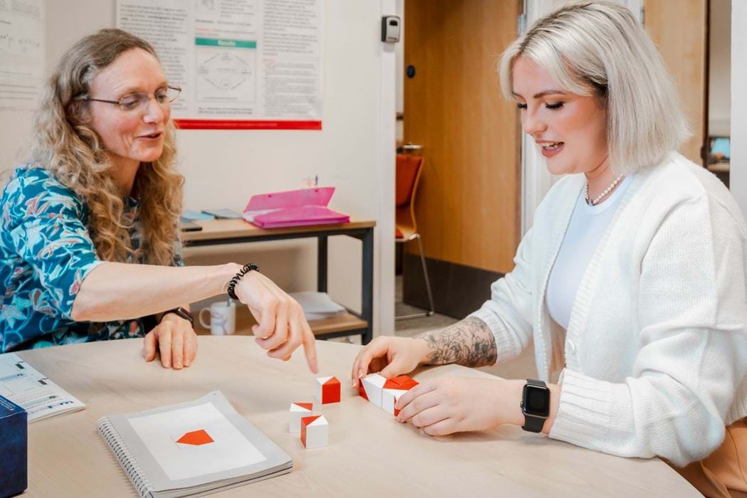 Female lecturer and female student conducting a psychology experiment with brick blocks.