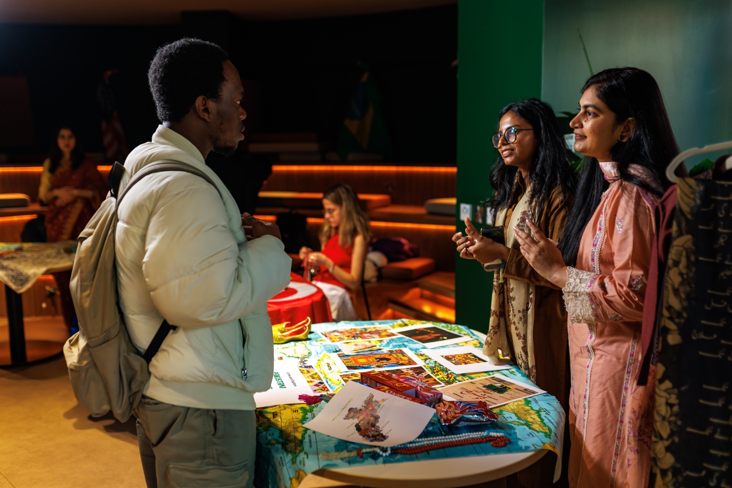 Three international students chatting in the library